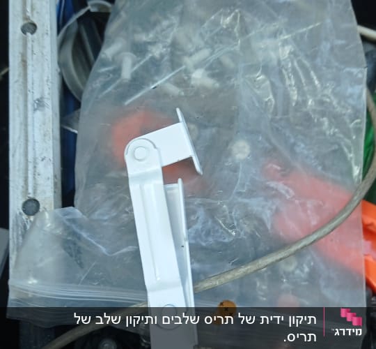 חלק מתכת לבן לתריסים בתוך קופסת כלים